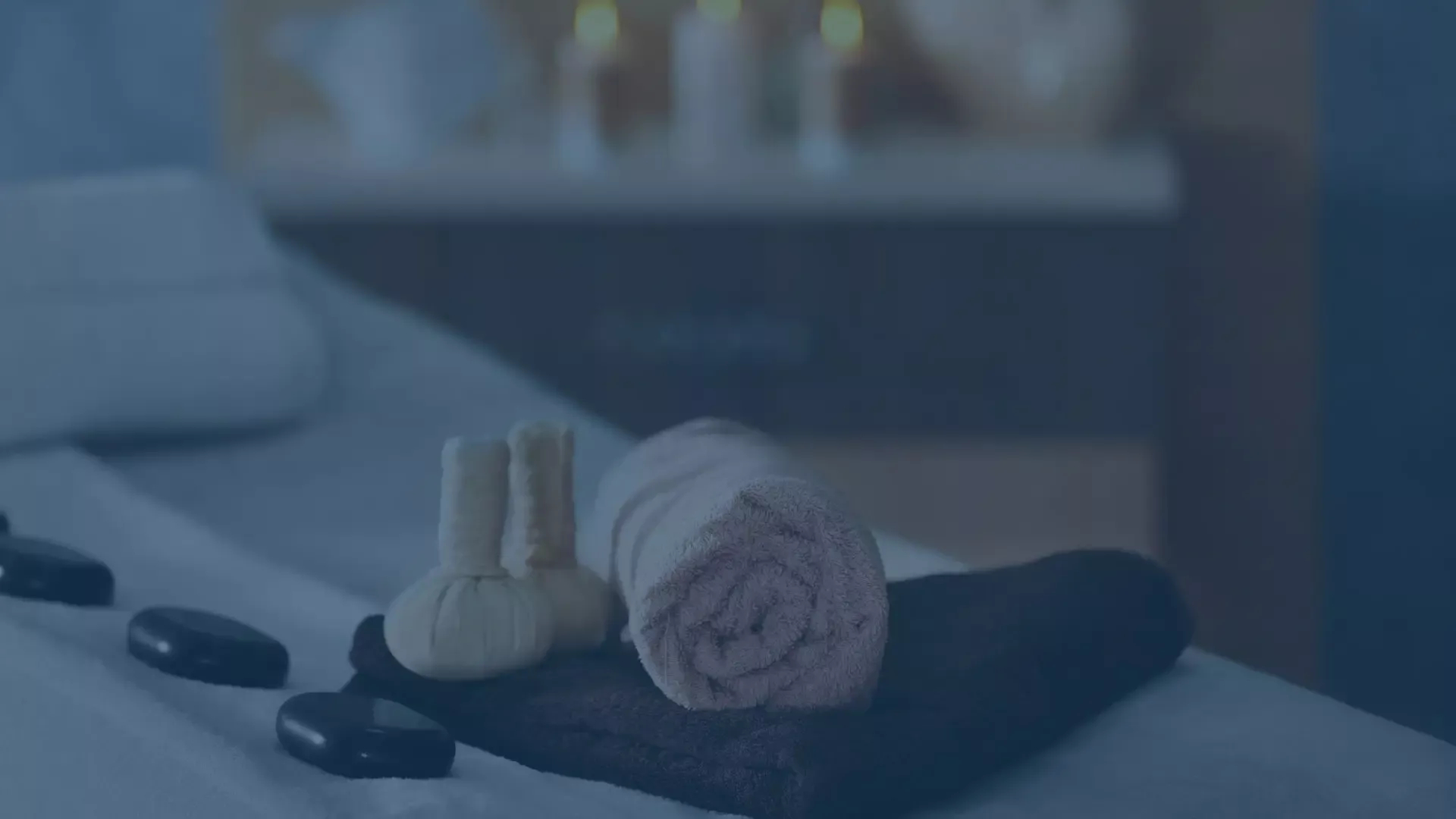 Wellnessbereich mit Massagesteinen und Handtüchern auf einer Liege, symbolisiert einen MDM Use Case für Mobile Device Management in der Wellnessbranche.