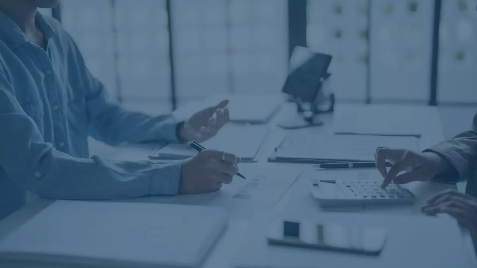 Zwei Personen besprechen Dokumente an einem Schreibtisch, symbolisiert IT-Beratung und Service Desk Excellence.